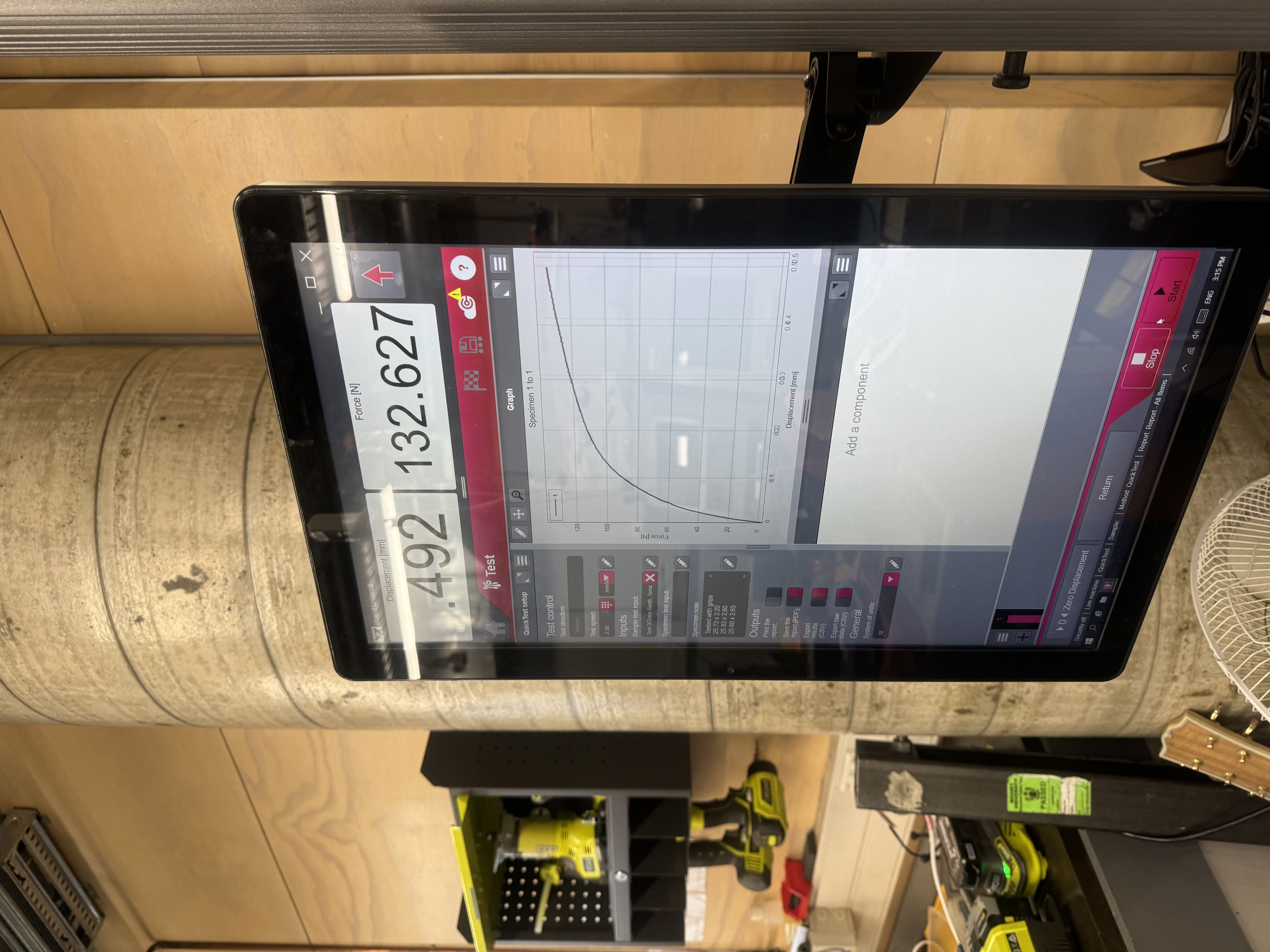 Instron display screen showing a force versus displacement graph from a tensile test