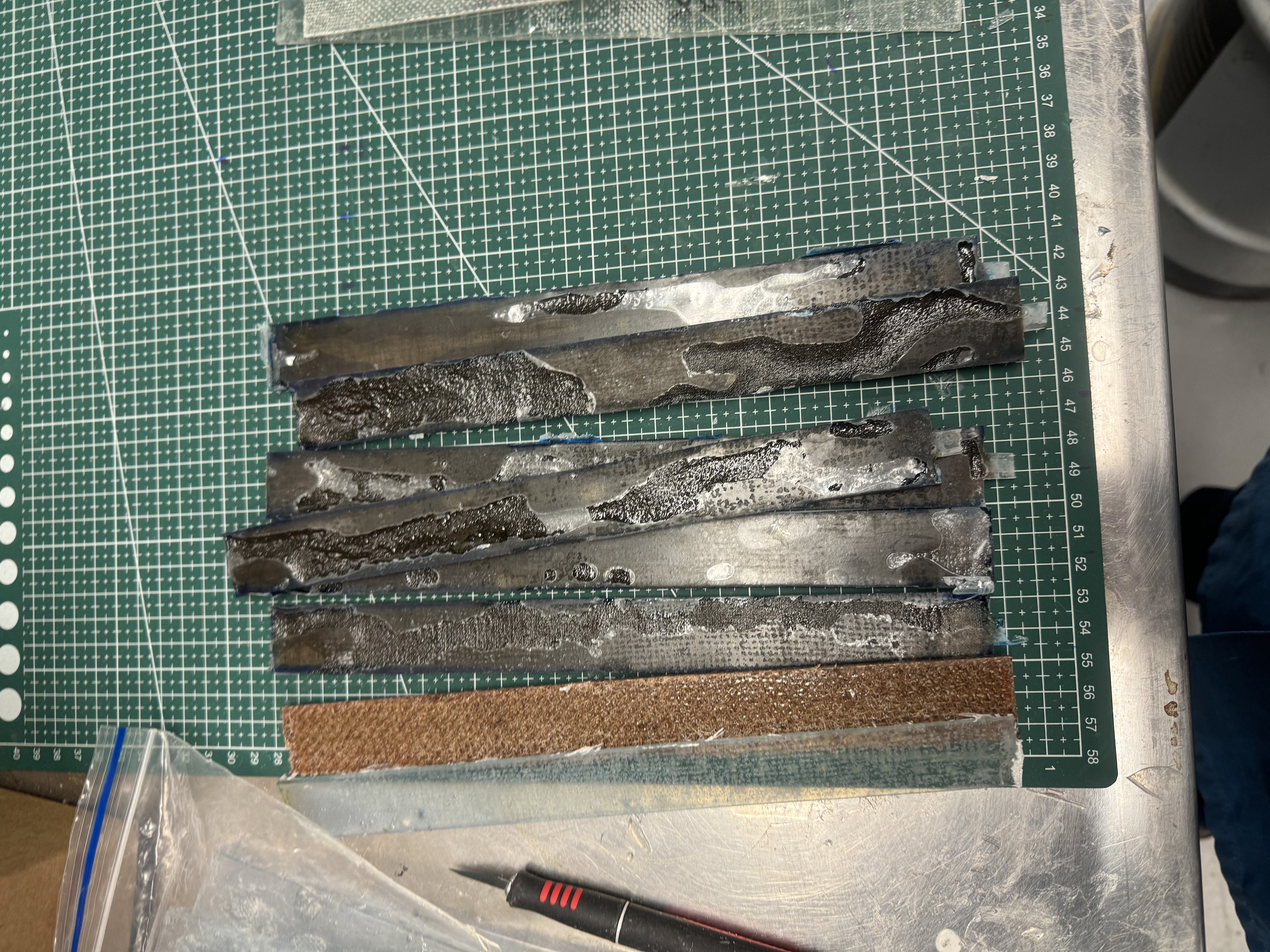 Cut composite test strips of different fibre types laid out for testing
