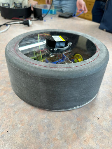 Real photo of the 3D-printed robot vacuum chassis with electronics visible inside
